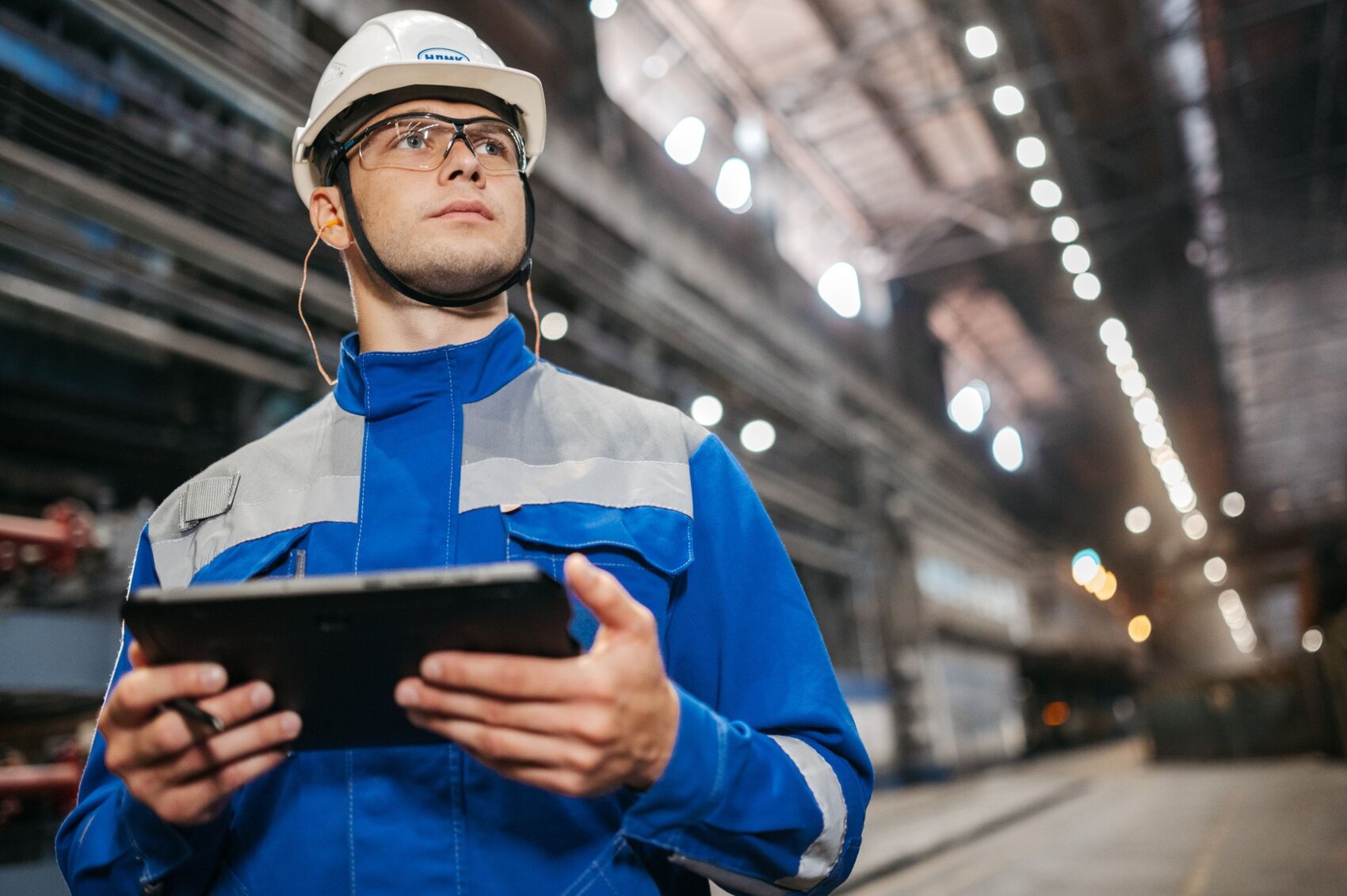 Technical professional reviewing operational conditions with a tablet